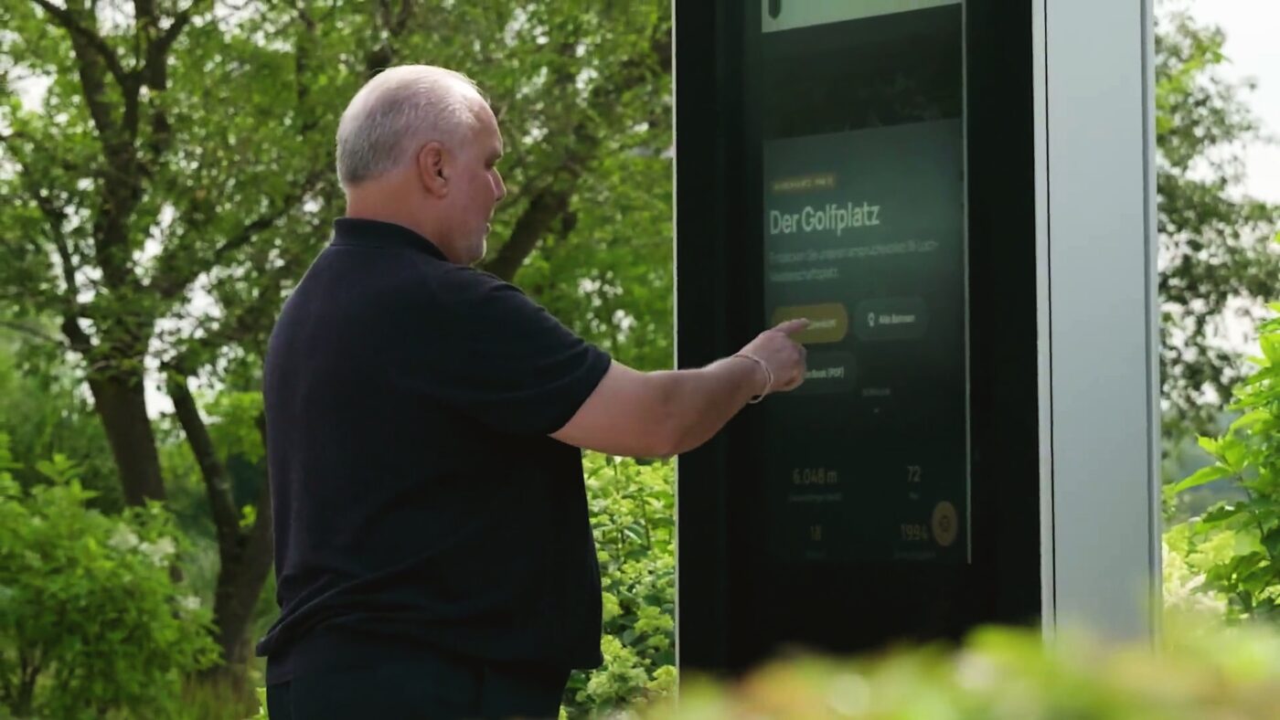 Das digitale Display auf der Anlage, Gäste im Gespräch davor